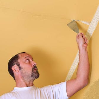 Sprekk i mur krafses forsiktig stor Sprekken krafses forsiktig stor